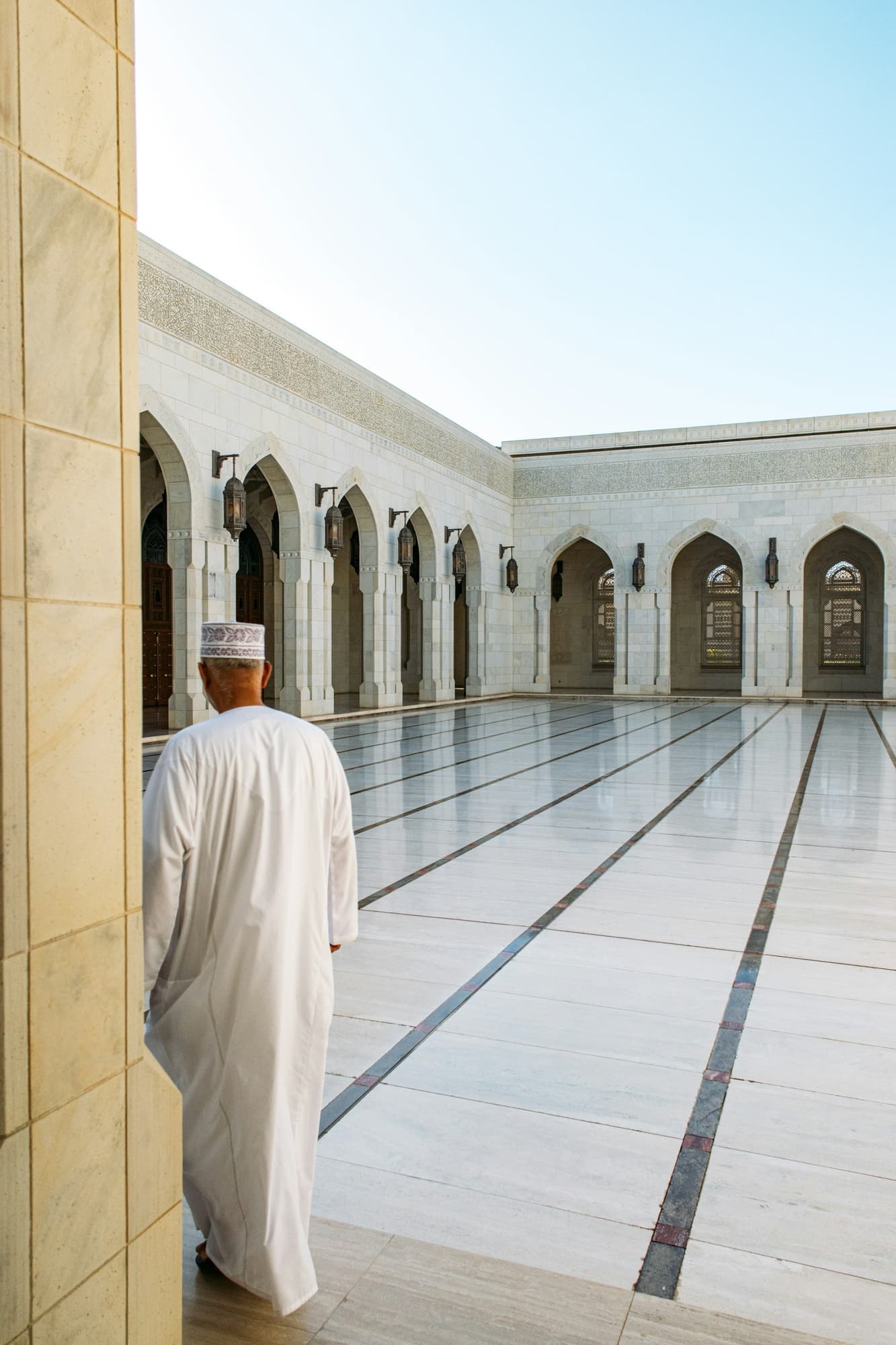 A client walking across a polished marble courtyard
