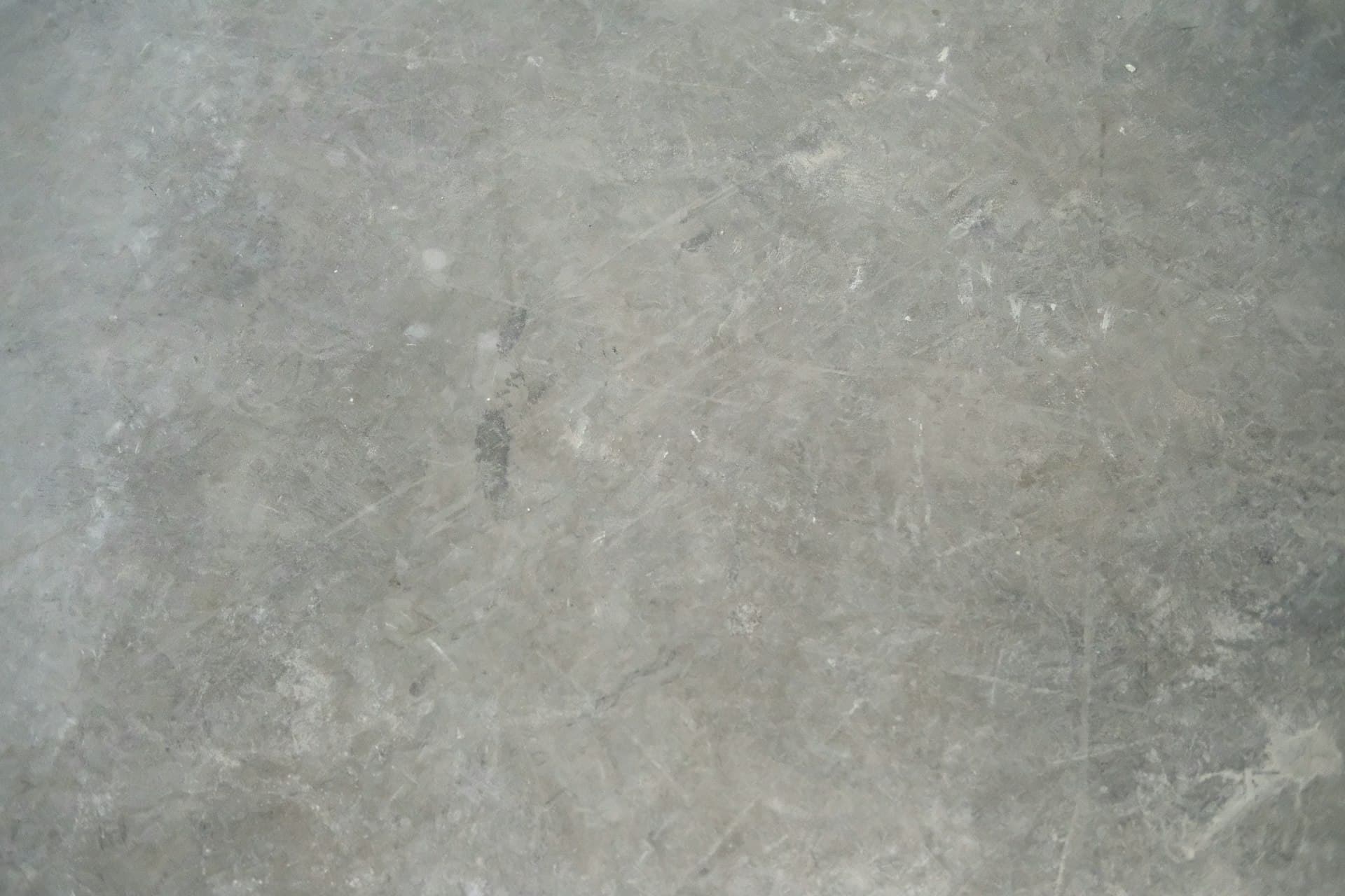 A dull, stained marble floor before polishing
